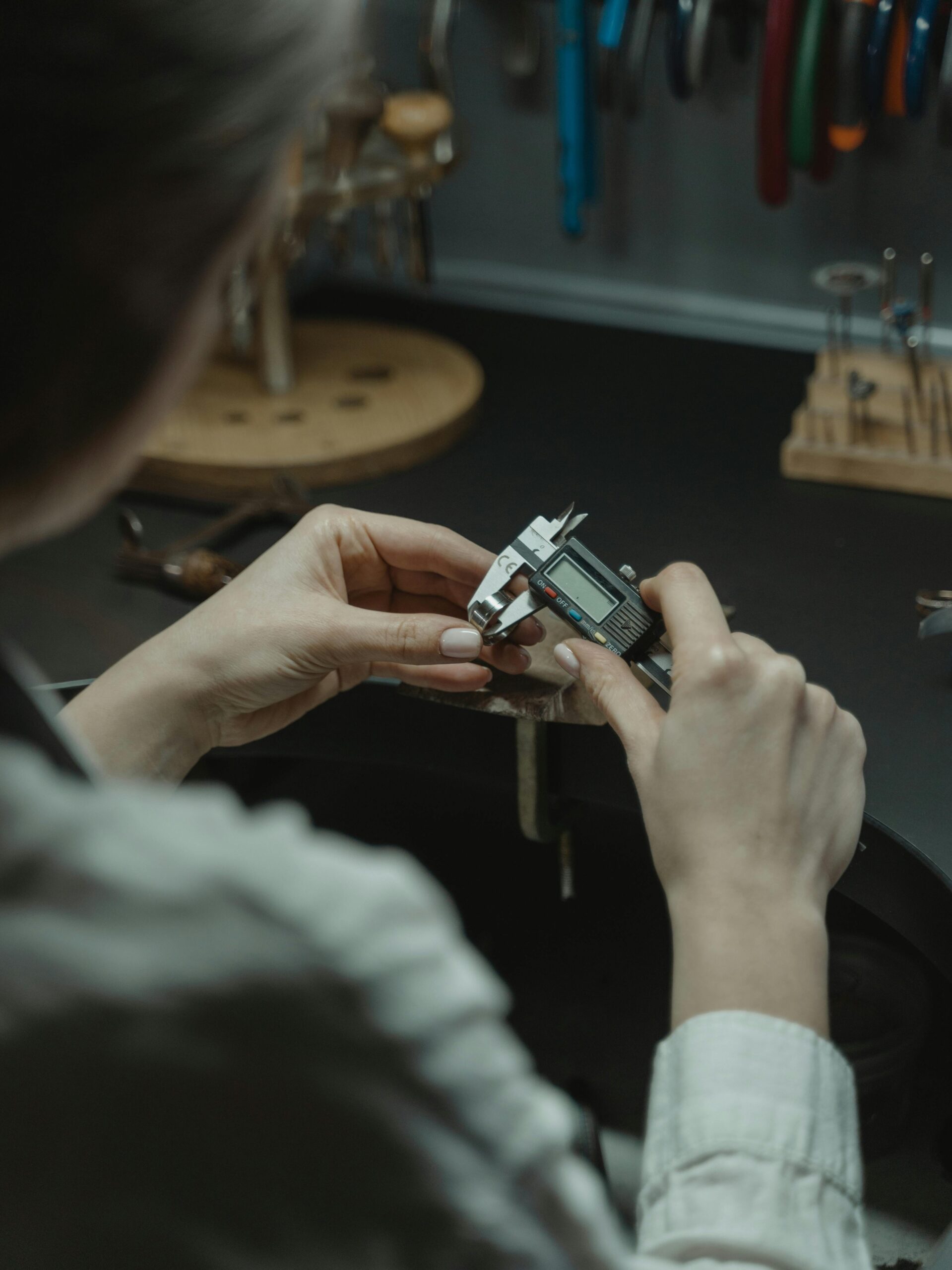 A jeweler uses a caliper to measure with precision in a professional workshop.